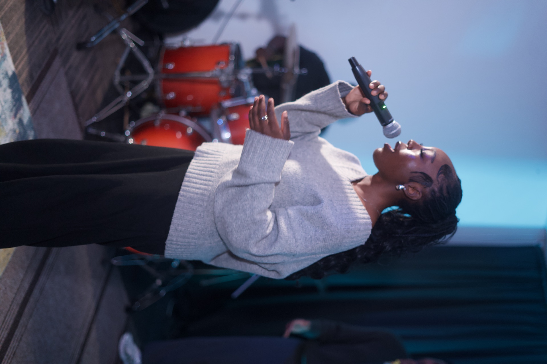 A woman kneeling in worship with her hand raised